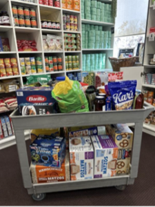 A large utility cart packed with boxed and canned goods.