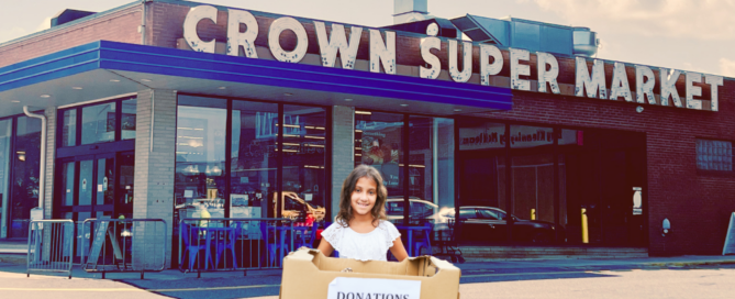 A young girl stands in front of The Crown Market holding a donation box.